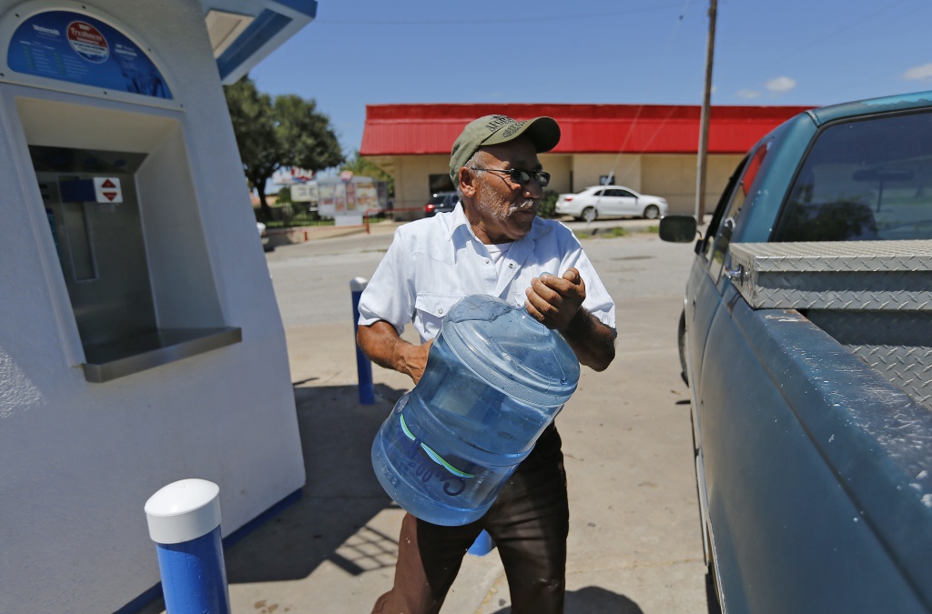 Bruni, Texas resident Abe Perez lifts a bottle of water into his truck at a water dispensary in Hebronville on Thursday, Aug. 25, 2016. Like many Bruni residents, Perez does not consume water from his faucets due to excess levels of arsenic found in the city's water system. However, officials on Thursday announced to Bruni residents that funding for an upcoming water filtration system will help remove the high levels of arsenic from their water system. The small unincorporated colonia three hours south of San Antonio has been dealing with undrinkable water from their taps for years. But with grant money through the United States Department of Agriculture Rural Development, Bruni residents of less than 400 people can eventually have water without the excess arsenic levels. The $2 million dollar project will put in a filtration system within two years for residents who have avoided drinking from their taps for over 10 years. (Kin Man Hui/San Antonio Express-News)